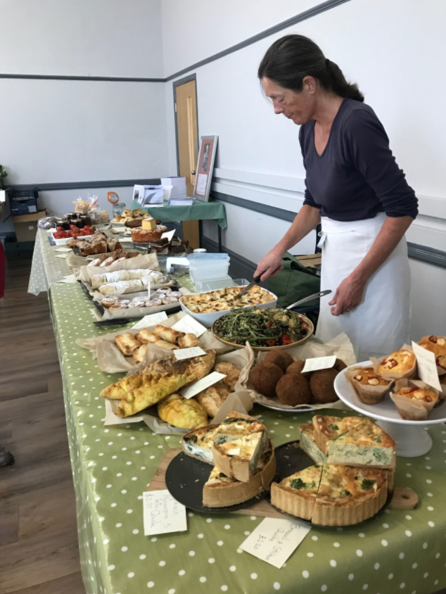 Woman serves food at a buffet gathering.